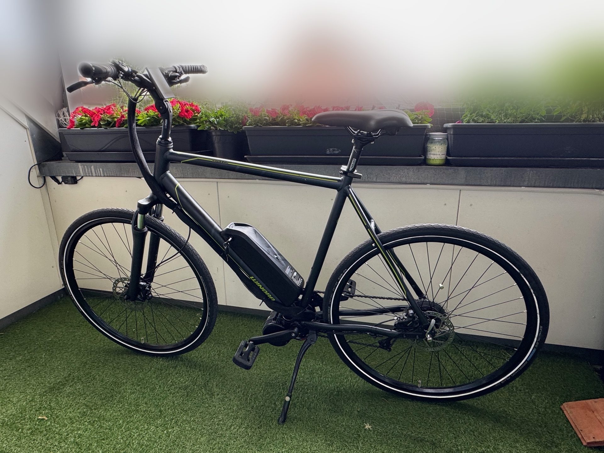 The converted bike on a balcony with the battery on the downtube and no lights, mudguards or rack fitted