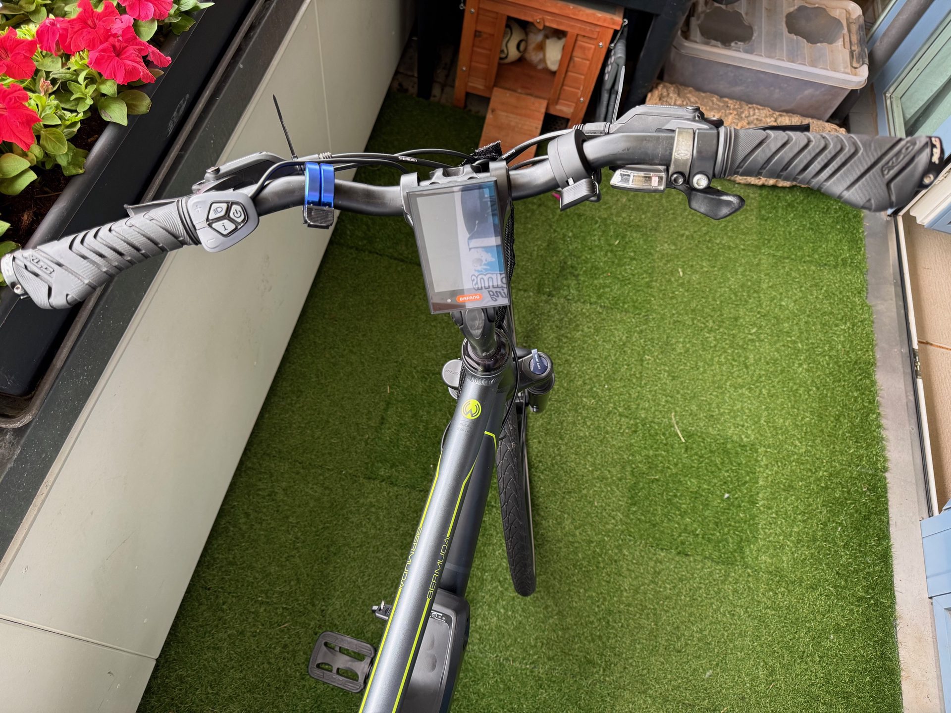 Looking down at the handlebars, with the stock Bafang display mounted in the middle and the assist control pad by the left grip